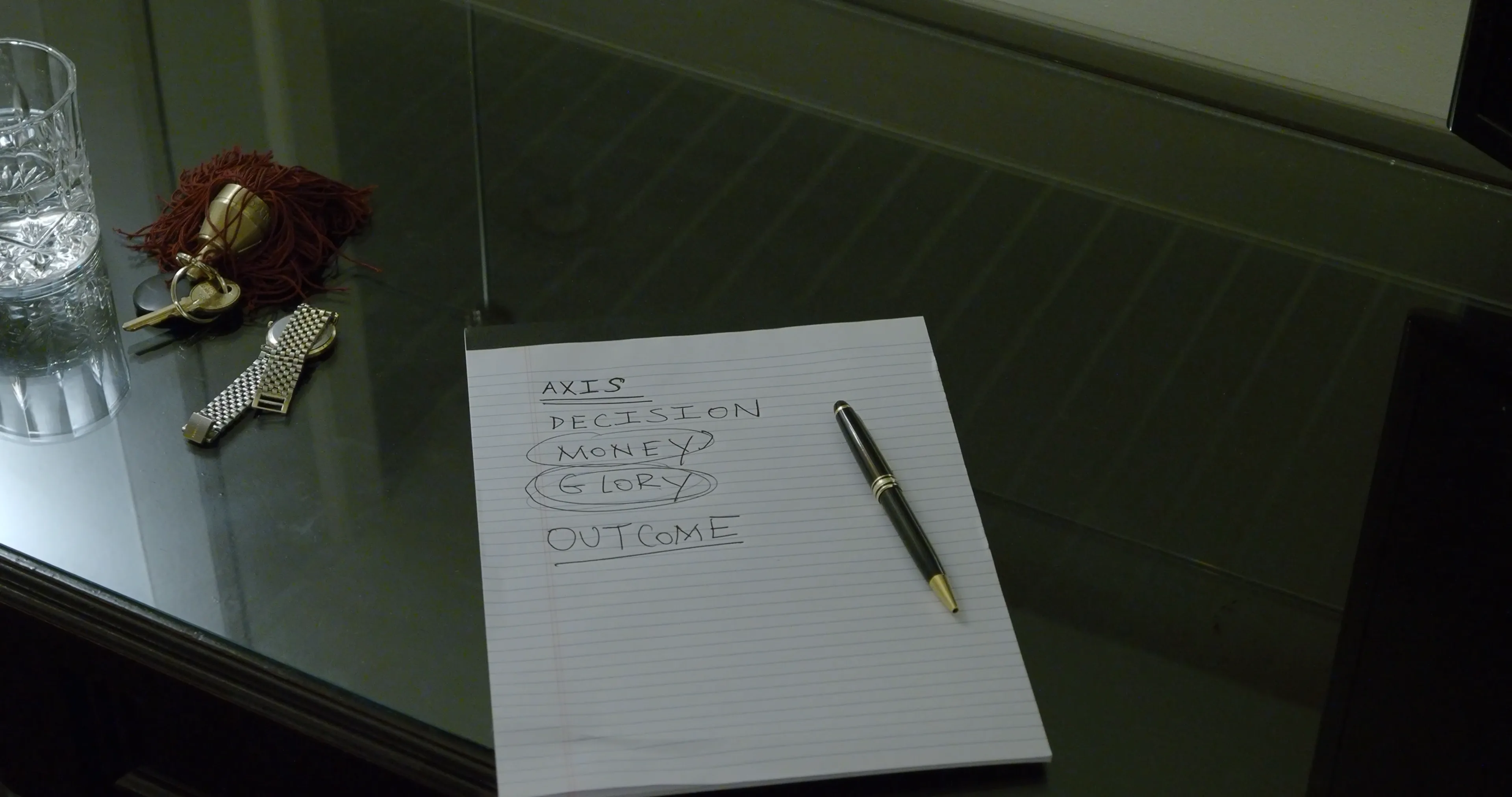 Ian Bloom as The Gangster in Big Time with paper and desk objects in a close interior