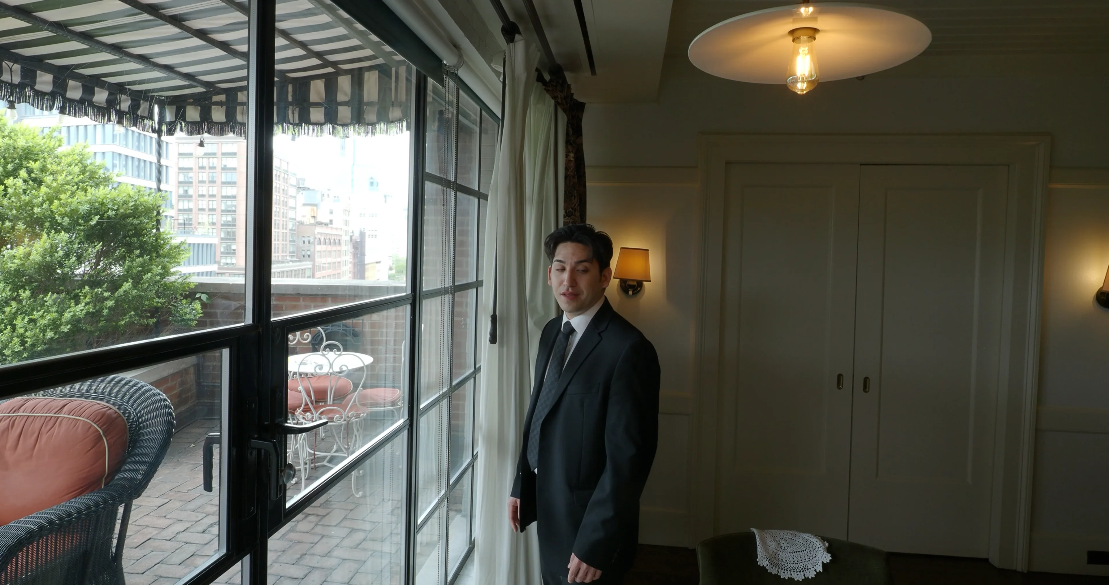 Ian Bloom as The Gangster in Big Time on the hotel terrace with the New York city view