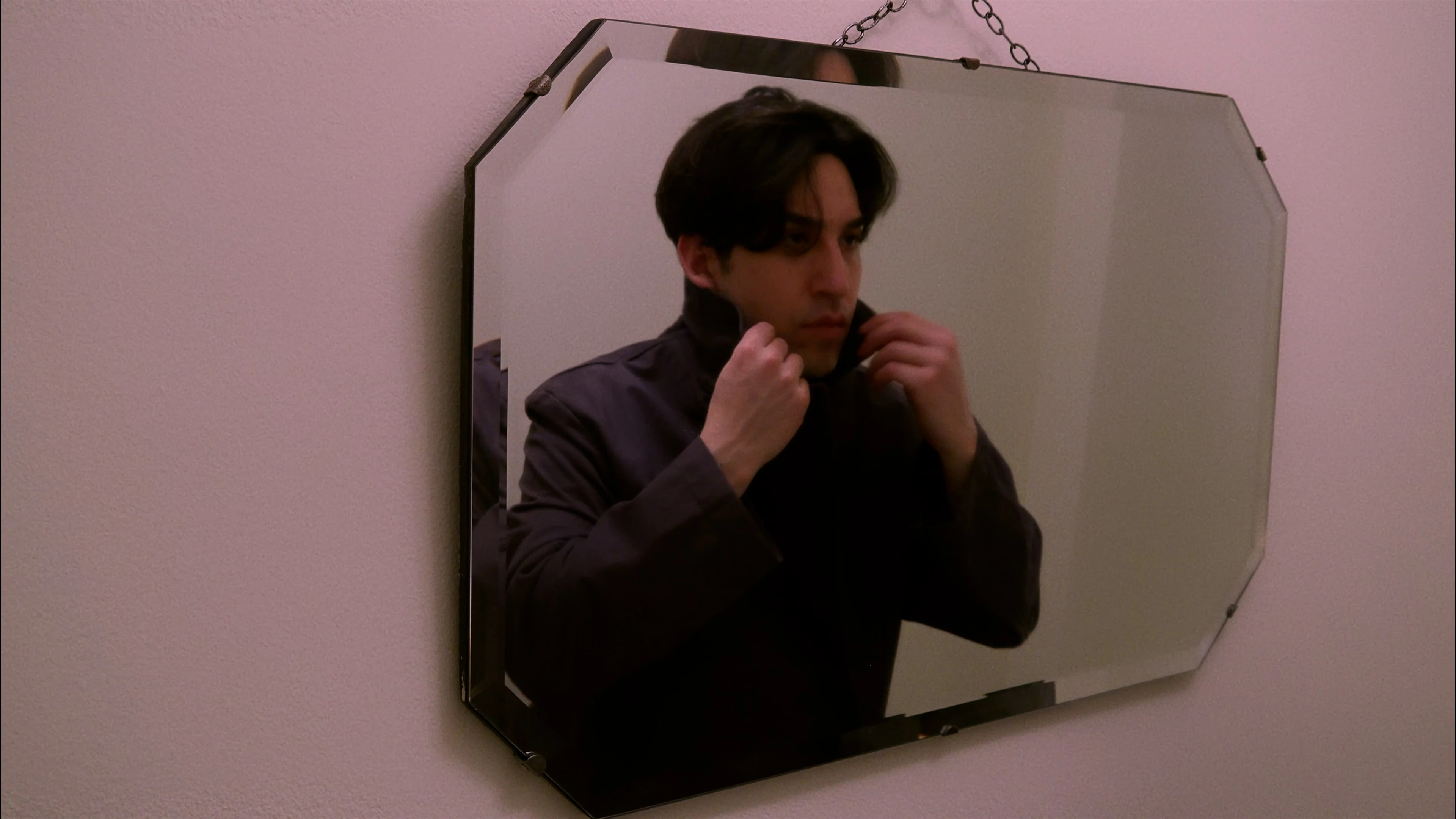 Ian Bloom in King aiming a gold handgun in a hotel interior