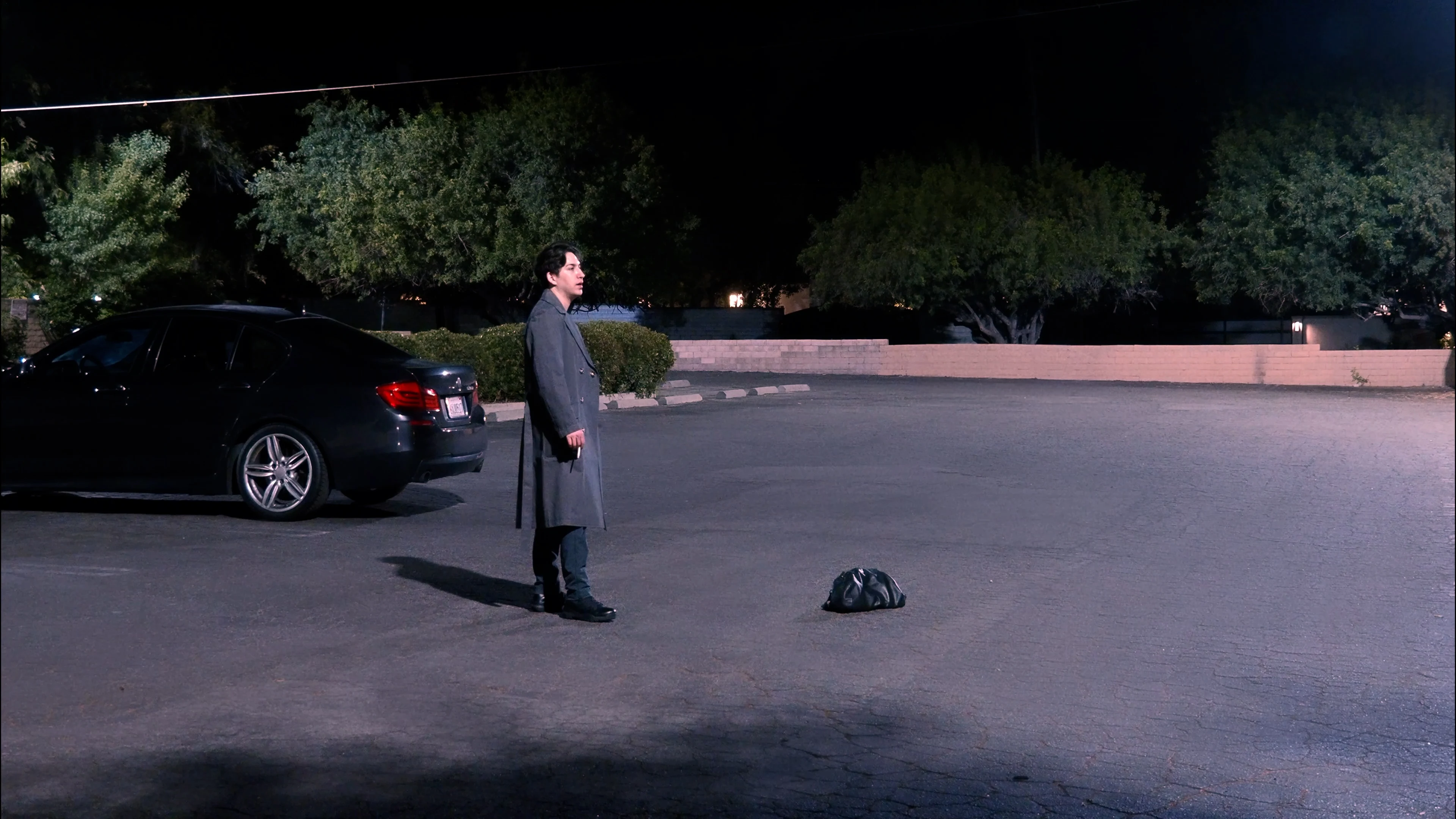 Ian Bloom in King entering an office in a gray suit carrying a black bag